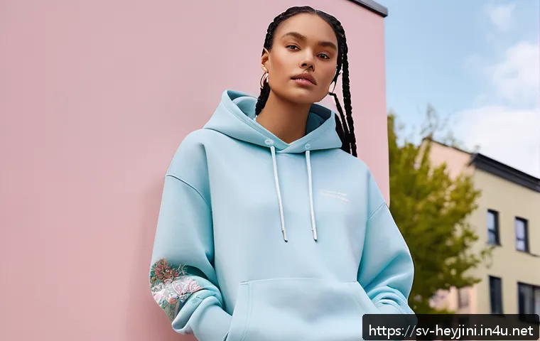헤이지니 굿즈 디자인 특징 - A cozy streetwear scene featuring a young adult wearing a pastel-colored oversized hoodie and sweatp...